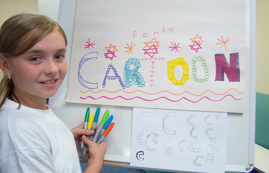 School pupil drawing cartoon lettering
